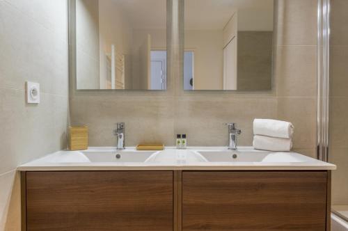 une salle de bain avec un lavabo blanc et un miroir dans l'établissement Le petit prince - Première conciergerie, à Montpellier