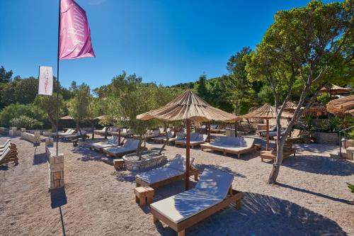 a group of lounge chairs and umbrellas on a beach at Korcula Hill in Korčula