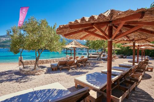 a beach with chairs and umbrellas and the water at Korcula Hill in Korčula