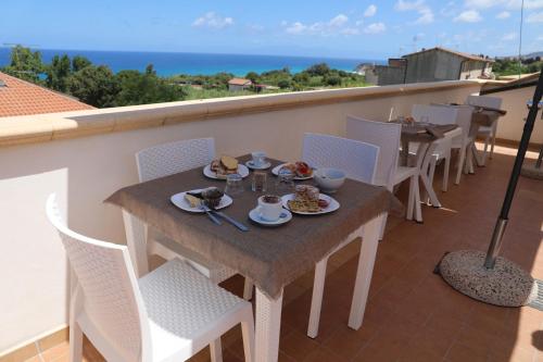 a table with plates of food on a balcony at Blue Marine - Free Parking in Tropea