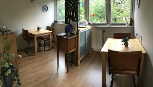 uma cozinha com duas mesas e uma mesa e cadeiras em Bed & Breakfast Ter Borg em Sellingen