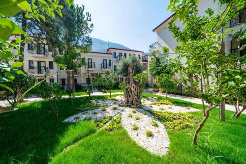 a garden with a tree in the middle of a building at Sundia By Liberty Oludeniz in Oludeniz