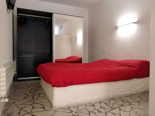 1 dormitorio con cama roja y espejo en Bologna Facile, en Bolonia