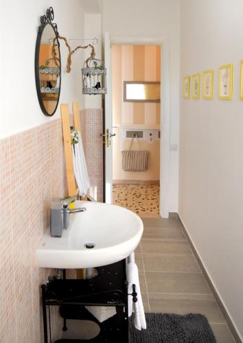 a bathroom with a white sink and a hallway at LìRìcordi in Isola del Liri
