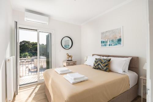 a white bedroom with a large bed with a window at Corfu Rooftop 45 in Corfu