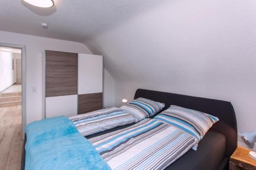 ein Schlafzimmer mit einem Bett mit gestreiften Kissen darauf in der Unterkunft Ferienwohnungen Schwabenhof in Schramberg