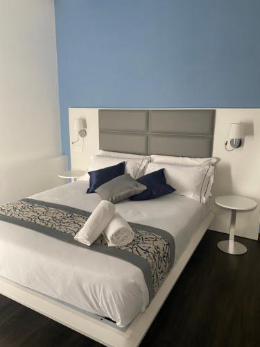 a large bed with white sheets and blue pillows at Palazzo Cappuccini Art Relais in Naples
