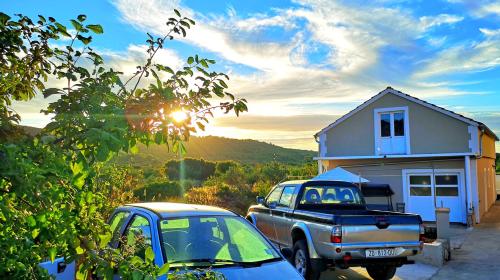 a couple of cars parked in front of a house at Island Cottage Apartment in Božava
