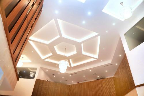 soffitto con struttura luminosa a forma di esagono in una stanza di KTDC Grand Chaithram a Trivandrum