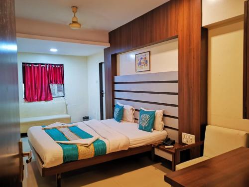 a bedroom with a bed and a table and a chair at Sai Sharan Stay Inn- Near MIDC Turbhe Navi Mumbai in Navi Mumbai