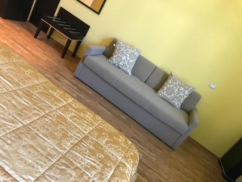 a couch in a living room with a piano at Hotel Villa Cinzia in Villanova Mondovì