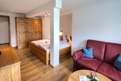 ein Wohnzimmer mit einem Sofa und einem Bett in der Unterkunft Gasthaus Pension Zum Löwen in Grafenhausen