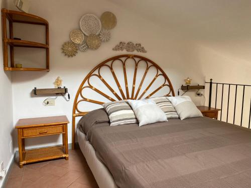 a bedroom with a bed with a large wooden headboard at APPARTAMENTINO ROMANTICO in Rio nellʼElba