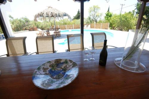 a wooden table with a bottle of wine and glasses at Nona's House in Kalamaki