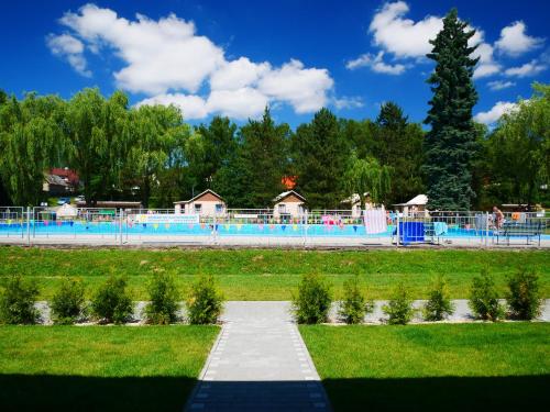 uma piscina num parque com relva e árvores em Camping Rožnov em Rožnov pod Radhoštěm