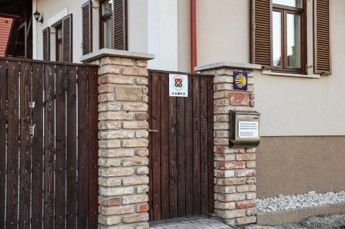 a wooden gate in front of a house at Szarvas apartman - Jakuzzis Vendégház Mány in Mány