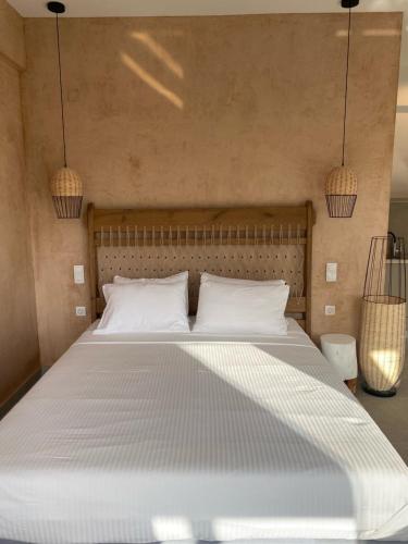 a large bed with white pillows in a bedroom at elia boutique hotel in Parga