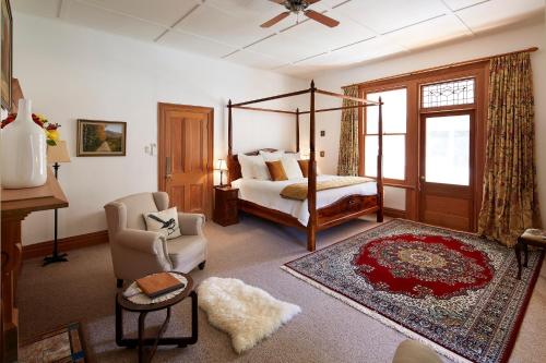 ein Wohnzimmer mit einem Bett und einem Stuhl in der Unterkunft Kaituna Valley Homestead in Little River