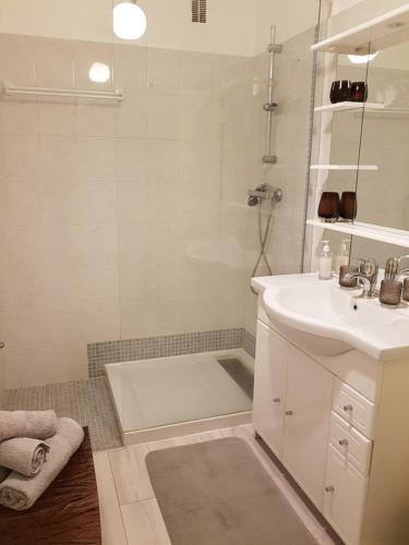uma casa de banho branca com um chuveiro e um lavatório. em Magnifique Studio Cannes em Cannes