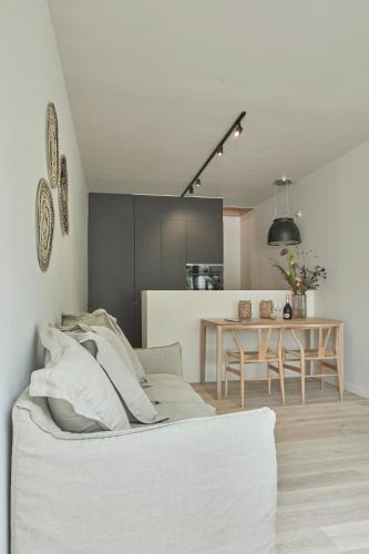 a living room with a white couch and a table at La Cigogne Boutique Suites in Retranchement