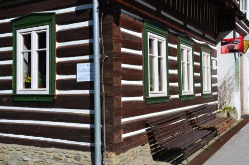 a bench on the side of a wooden building at Chalupa 335 in Vítkovice