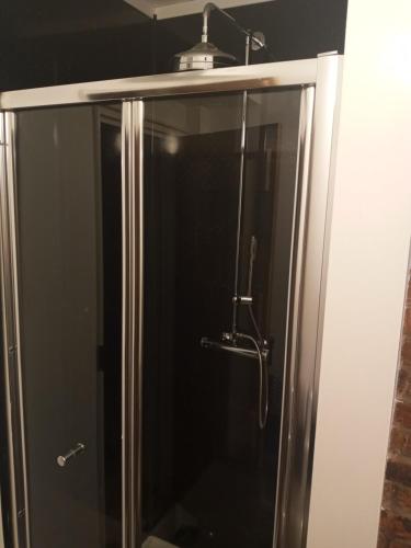 a shower with a glass door in a bathroom at Delighful self catering in the heart of Glastonbury in Glastonbury