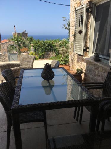 a glass table with a vase sitting on a balcony at The Mousehouse in Áno Rínglia