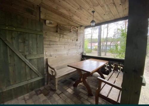 Habitación de madera con mesa de madera y banco en Kamiennikove en Kamiennik