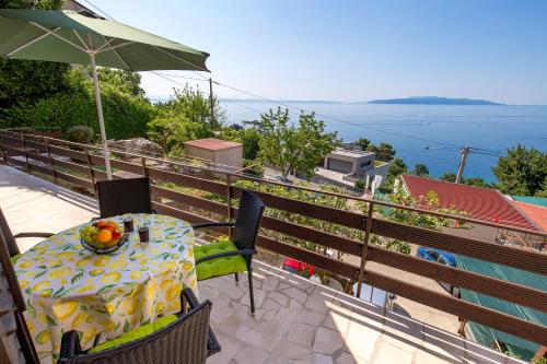 a table and chairs on a balcony with a view of the water at Apartments Vilma in Opatija