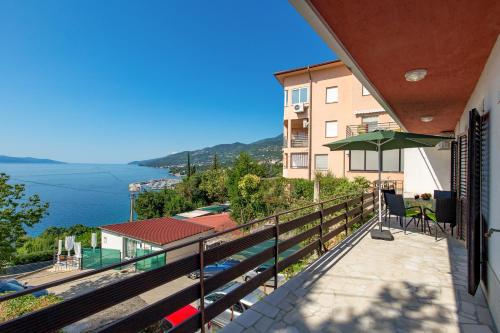 a balcony with an umbrella and a view of the water at Apartments Vilma in Opatija