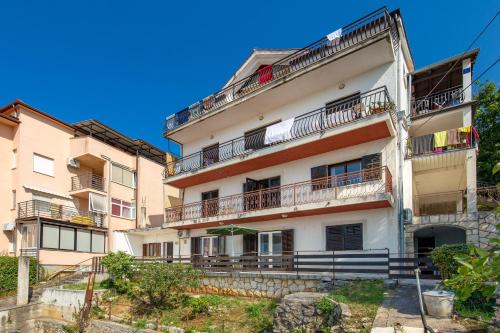 an apartment building with balconies and a blue sky at Apartments Vilma in Opatija