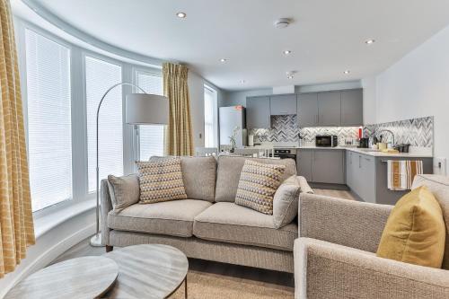 a living room with a couch and a kitchen at Finest Retreats - 13 Belle House - Apartment 3 in Filey
