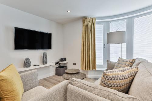 a living room with a couch and a flat screen tv at Finest Retreats - 13 Belle House - Apartment 3 in Filey
