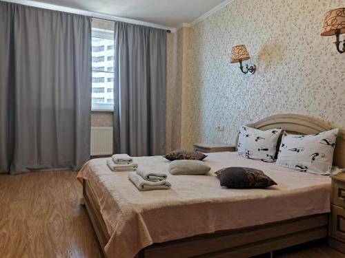 um quarto com uma cama grande e toalhas em Квартиры на берегу реки - ЖК Европейский em Krasnodar
