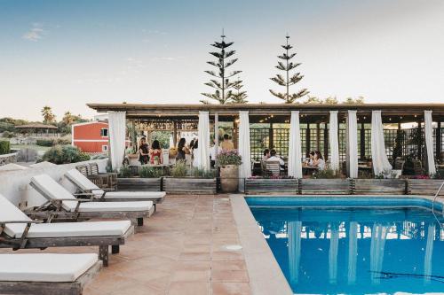 a pool at a resort with lounge chairs and a gazebo at Son Granot Hotel Rural & Restaurant in Es Castell