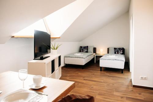 uma sala de estar com duas camas e uma televisão em Apartament Antonia em Sarnowy