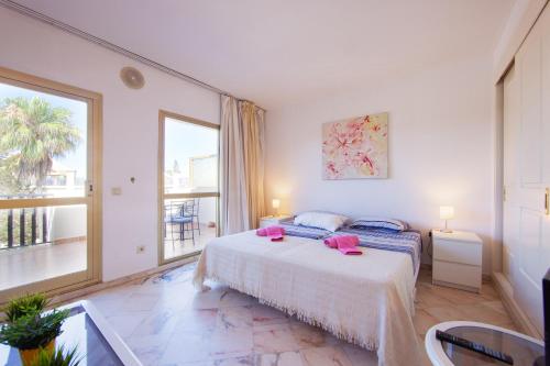 1 dormitorio con cama y ventana grande en Romana Playa studio Elviria, en Marbella