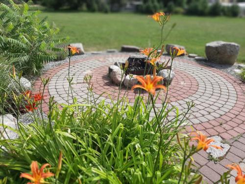 a brick patio with a fire pit in a garden at Holiday House & Sauna in Druskininkai in Neravai