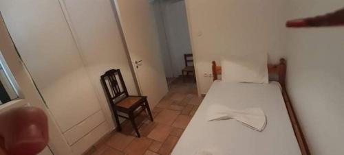 a small room with a white bed and a chair at SOILE GEORGIA-HOUSE in Loutra Edipsou