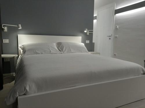 a white bed with white sheets and pillows at Kore Home in Olbia
