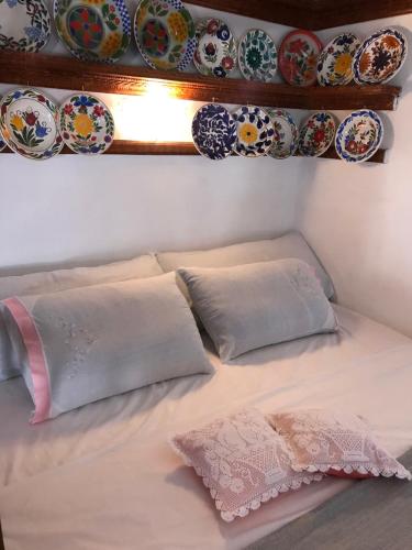 a bed with pillows and plates on the wall at Traditional House of Diafani in Karpathos Town