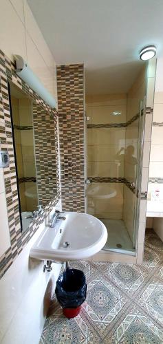 a bathroom with a sink and a glass shower at Apartment Luna in Ptuj