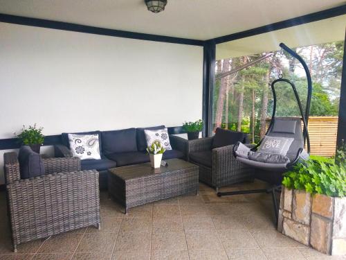 a patio with a couch and chairs and a table at Family Hotel Hebar in Batak