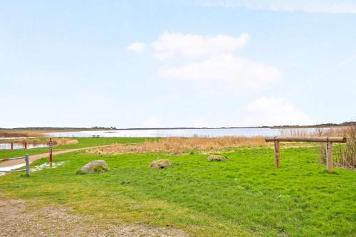 a park with a bench and a body of water at Ferielejlighed ved Vilsted Sø in Løgstør