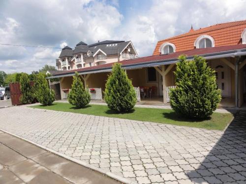 a large house with trees in front of a driveway at Apartmány Úsmev in Veľký Meder