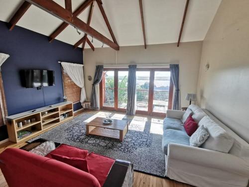 a living room with a couch and a tv at Happy Homes - Imhoffs Gift in Imhoffʼs Gift