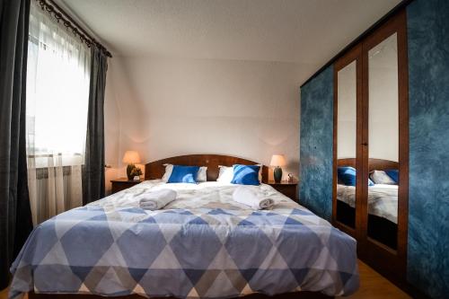 a bedroom with a blue and white bed with a window at Villa Vucipolje in Posušje