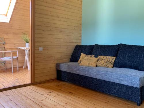 a blue couch in a room with a table at Lubāna mitrāja informācijas centrs in Abaine