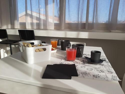a white table with a tray of food and drinks at Kore Home in Olbia
