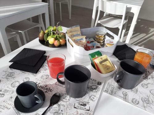 a table topped with cups and utensils on a table at Kore Home in Olbia